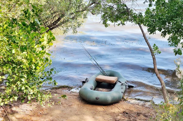 Barca gonfiabile sulla riva del lago. Canne e altre attività di pesca — Foto Stock