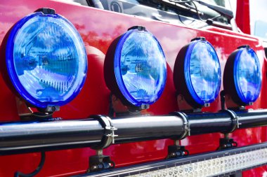Büyük, yuvarlak projektörler, ışıklar, mavi uyarı ışıkları, ön taraftaki itfaiye aracında sirenler.