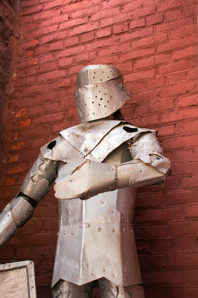 Knight's metal armor on a red wall background