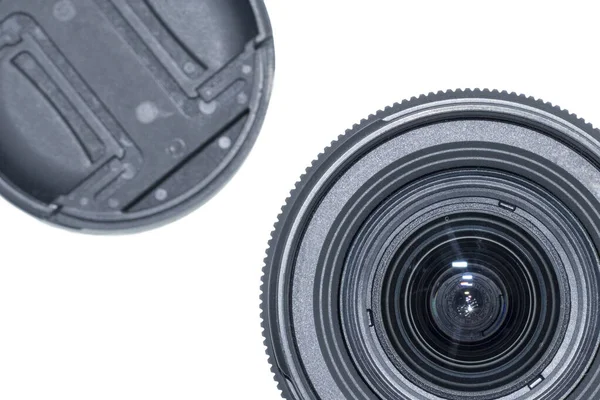 Part of black photo lens with protective cap on white background close up