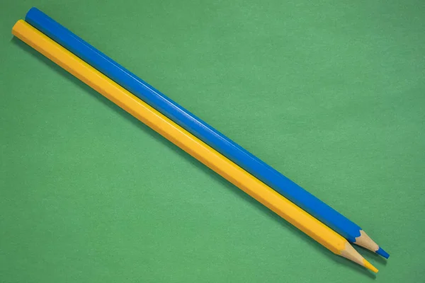 Kék Sárga Ceruzák Feküdt Egy Zöld Háttér Közelkép — Stock Fotó