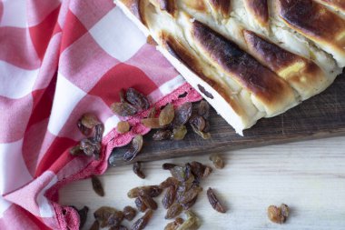 Tatlı süzme peynirle yuvarlan ve kırmızı-beyaz kumaş üzerinde kuru üzümler