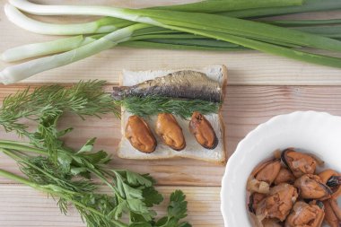 Ahşap bir arka planda, deniz ürünleri ve otlu sandviç.