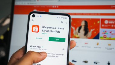 Asyalı bir adamın eli akıllı telefonu tutuyor ve Dumai, Endonezya 'da 11 Haziran 2021' de Shopee uygulamasını açıyor..