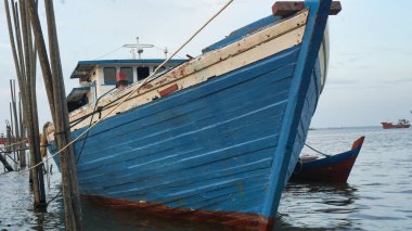 Balıkçı tekneleri, mavi bir balıkçı teknesi olan Dumai kasabasının balıkçı teknesine yanaşıyor.