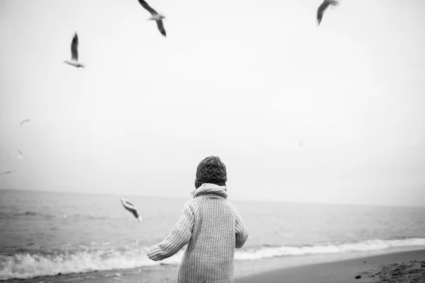 Menina em roupas quentes na praia — Fotografia de Stock