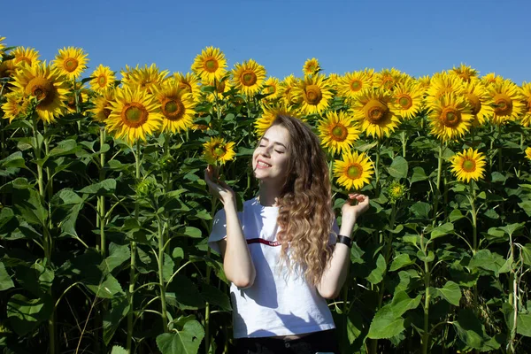 一个长金发的欧洲姑娘站在向日葵上 — 图库照片