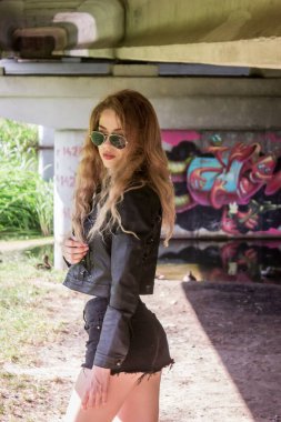 Rusya, Korolev - 08 / 27 / 2019: Grafiti arka planında gözlüklü bisikletçi kız