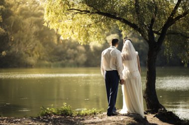 Gelin ve damat ağacın altında duran 