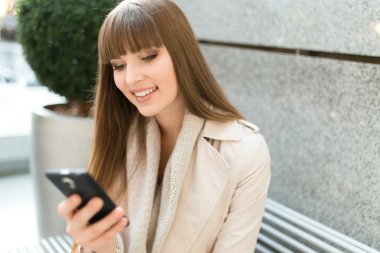 cep telefonu kullanan genç kadın