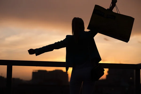 Silueta femenina sobre la ciudad puesta del sol —  Fotos de Stock