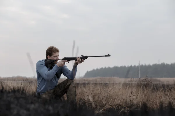 Huntsman s puškou na pole — Stock fotografie