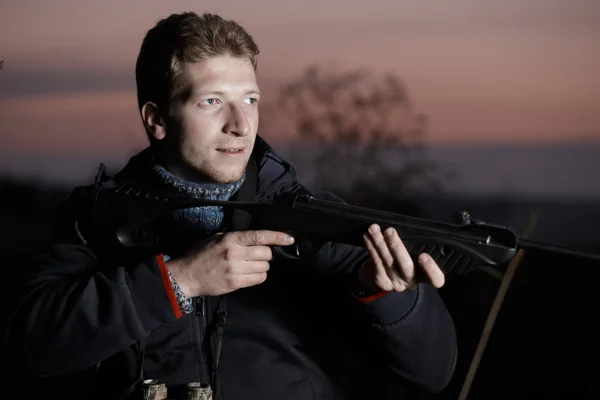 Huntsman with rifle at field — Stock Photo, Image