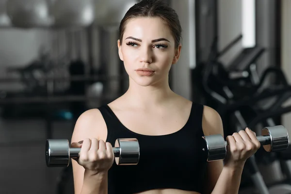 Vrouw tilt halters in de sportschool. — Stockfoto