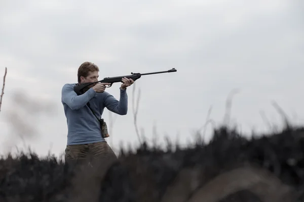 Jäger mit Gewehr auf Feld — Stockfoto