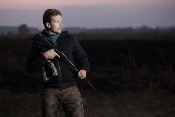 Охотник с винтовкой на поле — стоковое фото
