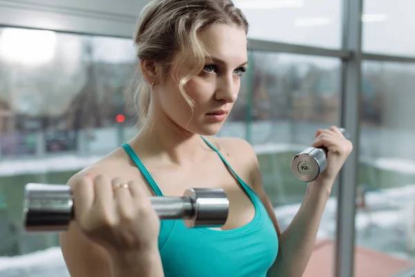 Vackra idrottskvinna med hantlar i gym — Stockfoto