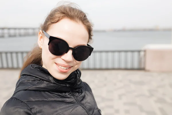Glada leende flicka i solglasögon. — Stockfoto