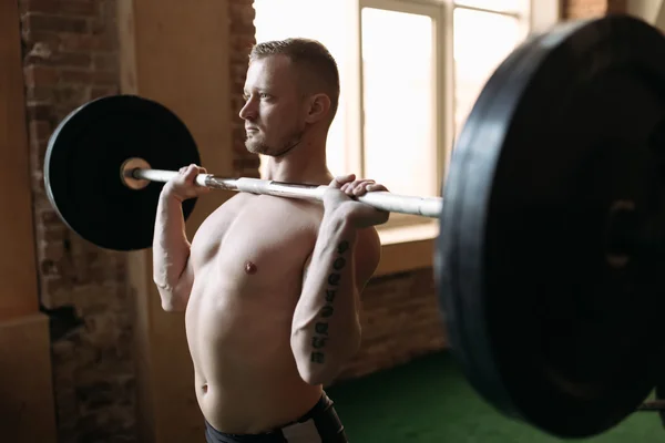 Homem forte levantando barbell — Fotografia de Stock