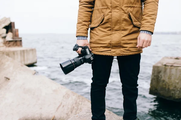 Man holding camera near sea — Stock Photo, Image