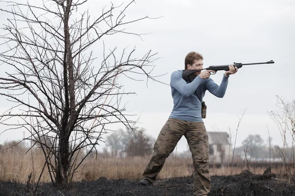 Jäger mit Gewehr auf Feld — Stockfoto