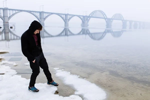 Mies seisoo jääjoella — kuvapankkivalokuva
