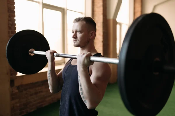 Homem forte levantando barbell — Fotografia de Stock