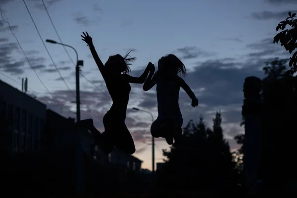 Silhouet van springen vrienden — Stockfoto