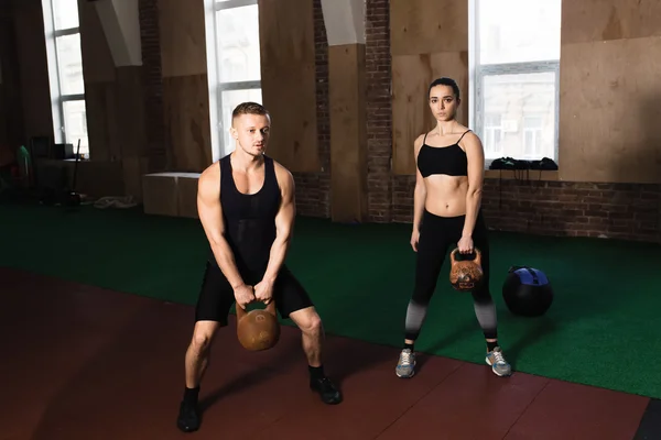 Man and woman training kettle bells — Stock Photo, Image