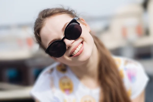 Glada leende flicka i solglasögon. — Stockfoto