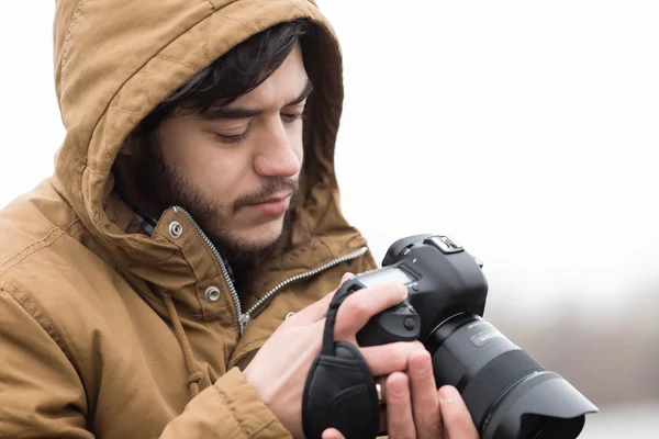 Valokuvaaja säätää kameraa — kuvapankkivalokuva