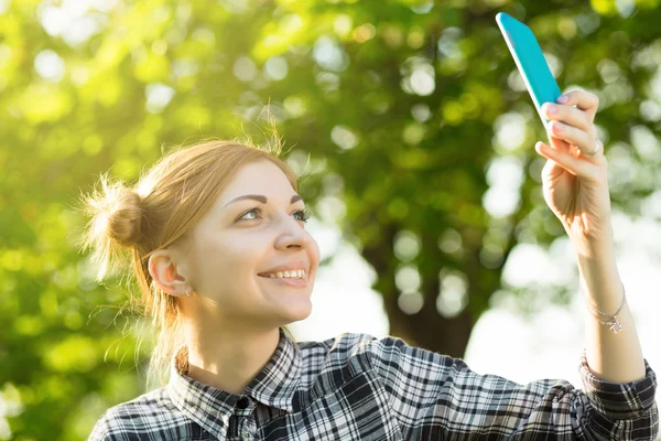 Young woman take a photo using smartphone in the park — Stock Photo, Image