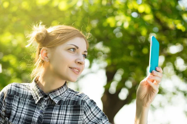 Young woman take a photo using smartphone in the park — Stock Photo, Image