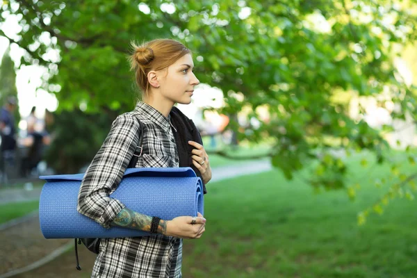 女性が公園でマットを運ぶ — ストック写真