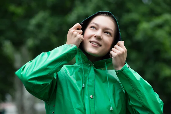 Wanita muda berjas hujan memegang kerudung — Stok Foto