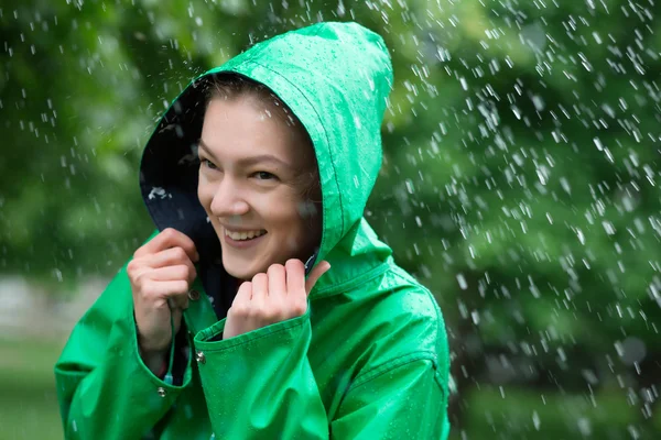 Mulher de capa de chuva sorrindo no dia chuvoso — Fotografia de Stock