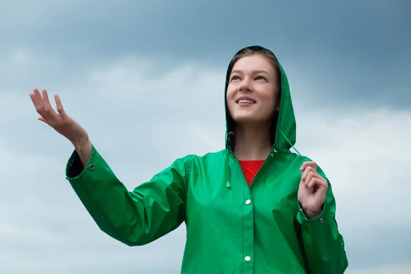 Mulher de capa de chuva em fundo céu nublado — Fotografia de Stock