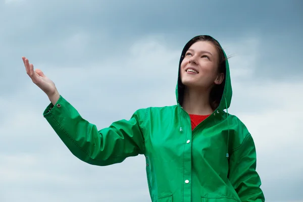 Mujer en impermeable en el fondo del cielo nublado —  Fotos de Stock