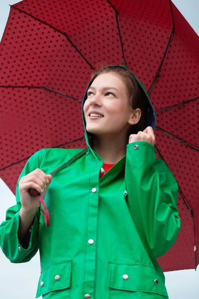 曇り空を背景に傘を保持しているレインコートの女 — ストック写真