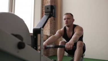 Onun tren üzerinde kürek egzersiz yapan erkek