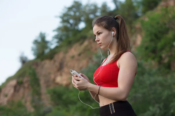 Девушка слушает музыку перед пробежкой — стоковое фото