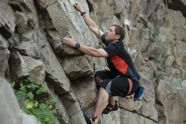 Maschio arrampicatore si aggrappa a una scogliera — Foto Stock