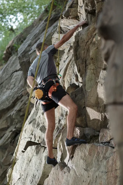 Masculino alpinista escalando uma estrutura de pedra — Fotografia de Stock