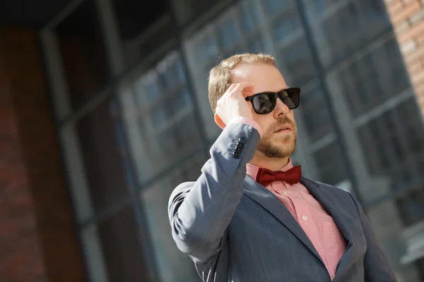 Стильний бізнесмен в сонцезахисних окулярах, що йдуть у центрі міста — стокове фото