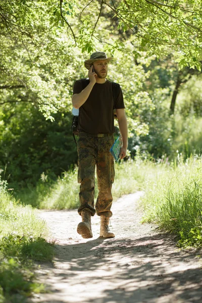Männlicher Tourist läuft im Wald auf Wanderschaft und spricht per Handy — Stockfoto