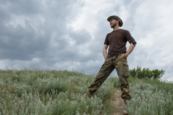 Sure man standing in field at moody sky background — Stock Photo, Image