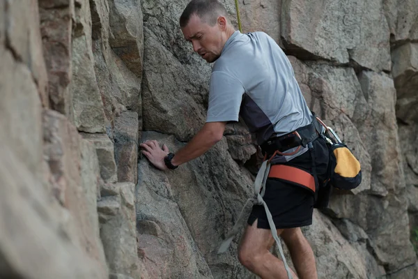 Masculino alpinista apega-se a um penhasco — Fotografia de Stock
