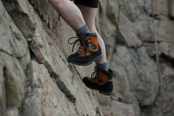 Gambe di arrampicatore maschio aggrappate a una scogliera — Foto Stock