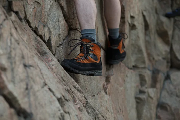 Legs of male rock climber clings to a cliff — Stock Photo, Image