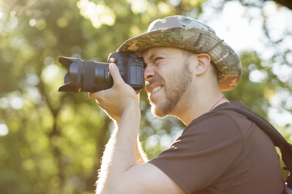 Valokuvaaja ammunta DSLR kamera metsässä — kuvapankkivalokuva